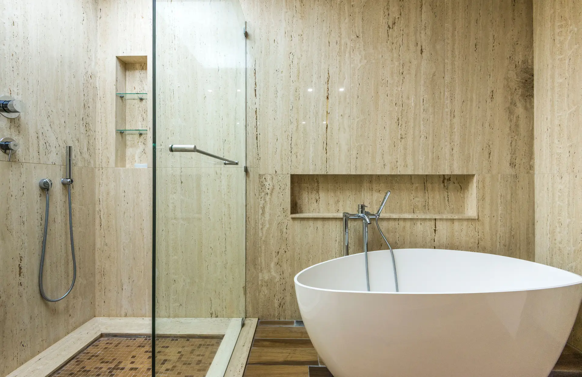 Minimalist limestone bathroom with freestanding soaking tub and monolithic stone walls